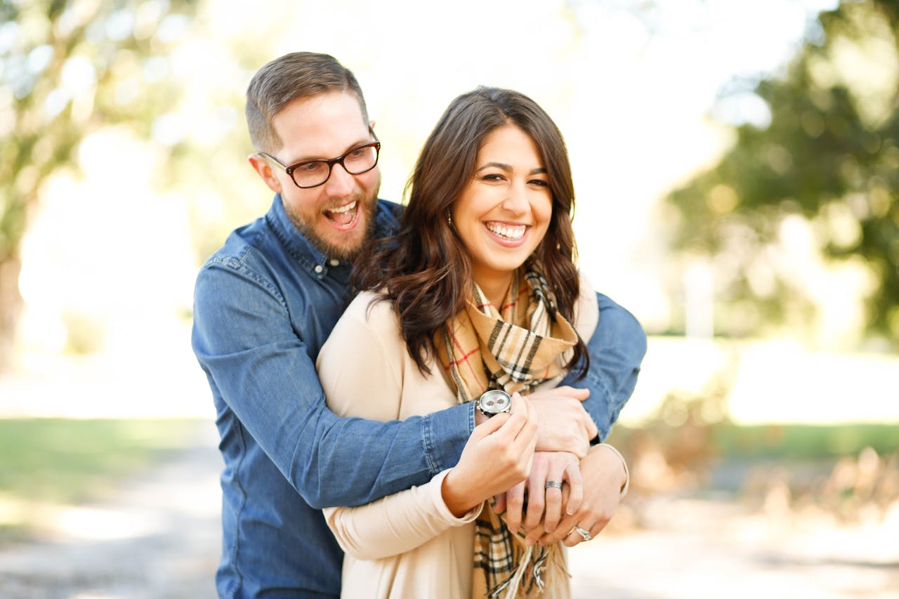 about-04 A happy couple enjoying an outdoor engagement photoshoot with laughter and love.