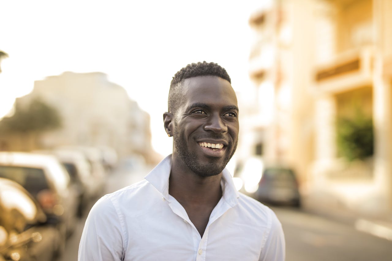 why-choose-us-02 Portrait of a cheerful man outdoors in a city setting, expressing happiness and style.